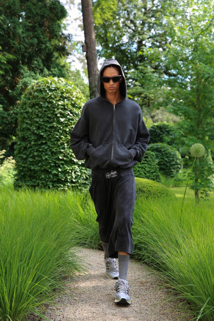A relaxed black hoodie with long sleeves paired with wide-leg black pants.