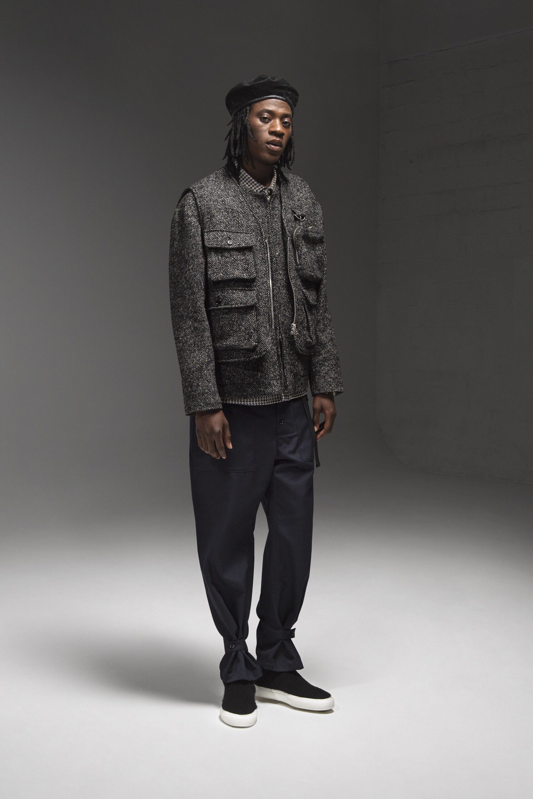 A relaxed-fit gray wool jacket with long sleeves and collared design paired with black pants.