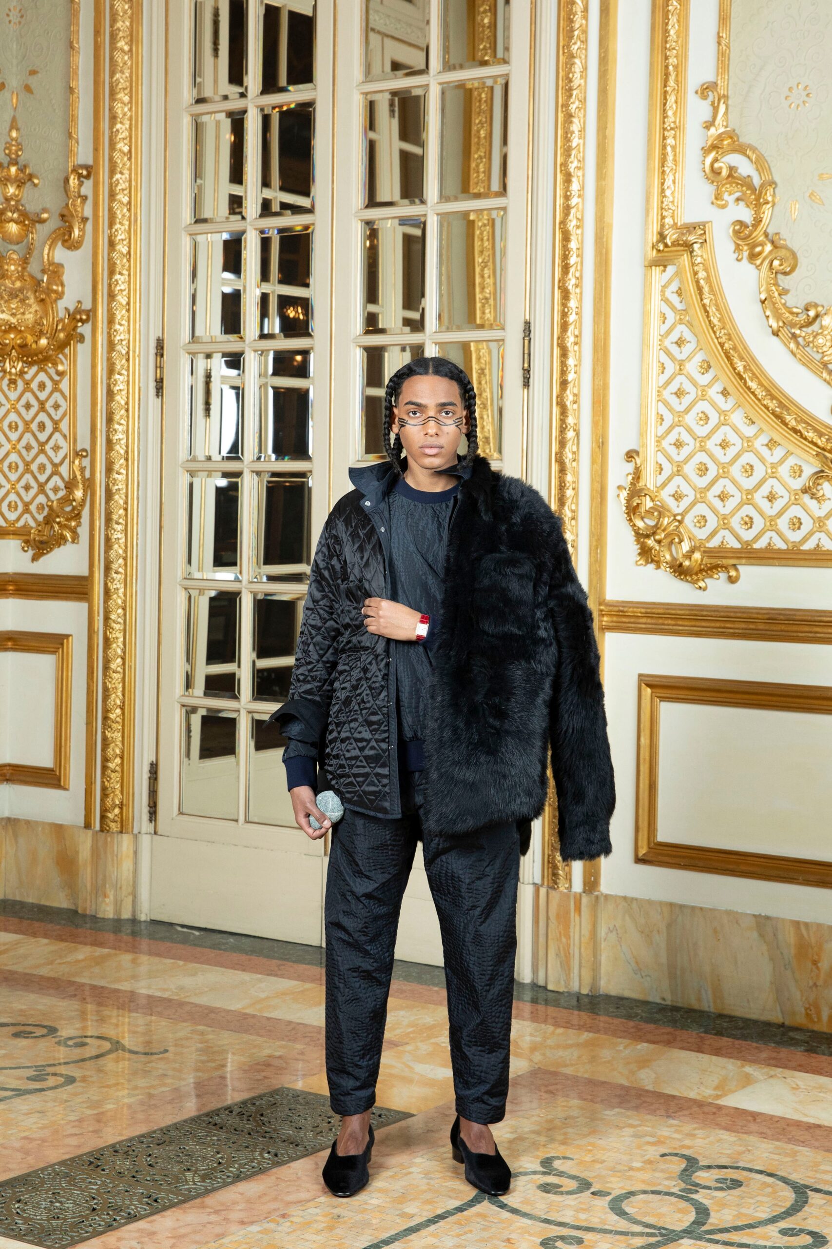 A fitted black leather jacket with long sleeves and collared design paired with matching pants.