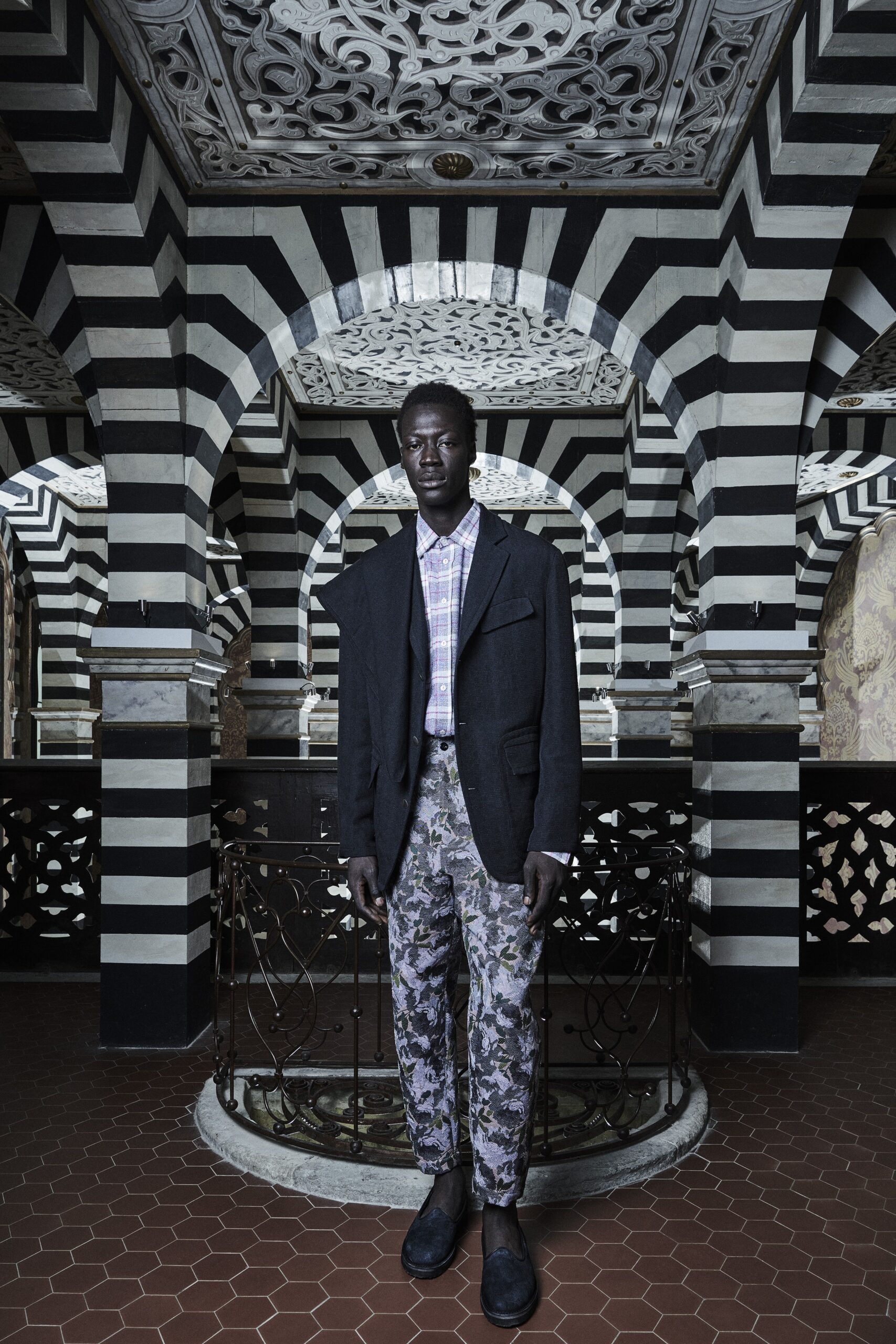 A relaxed black jacket paired with gray printed pants featuring a collared design.