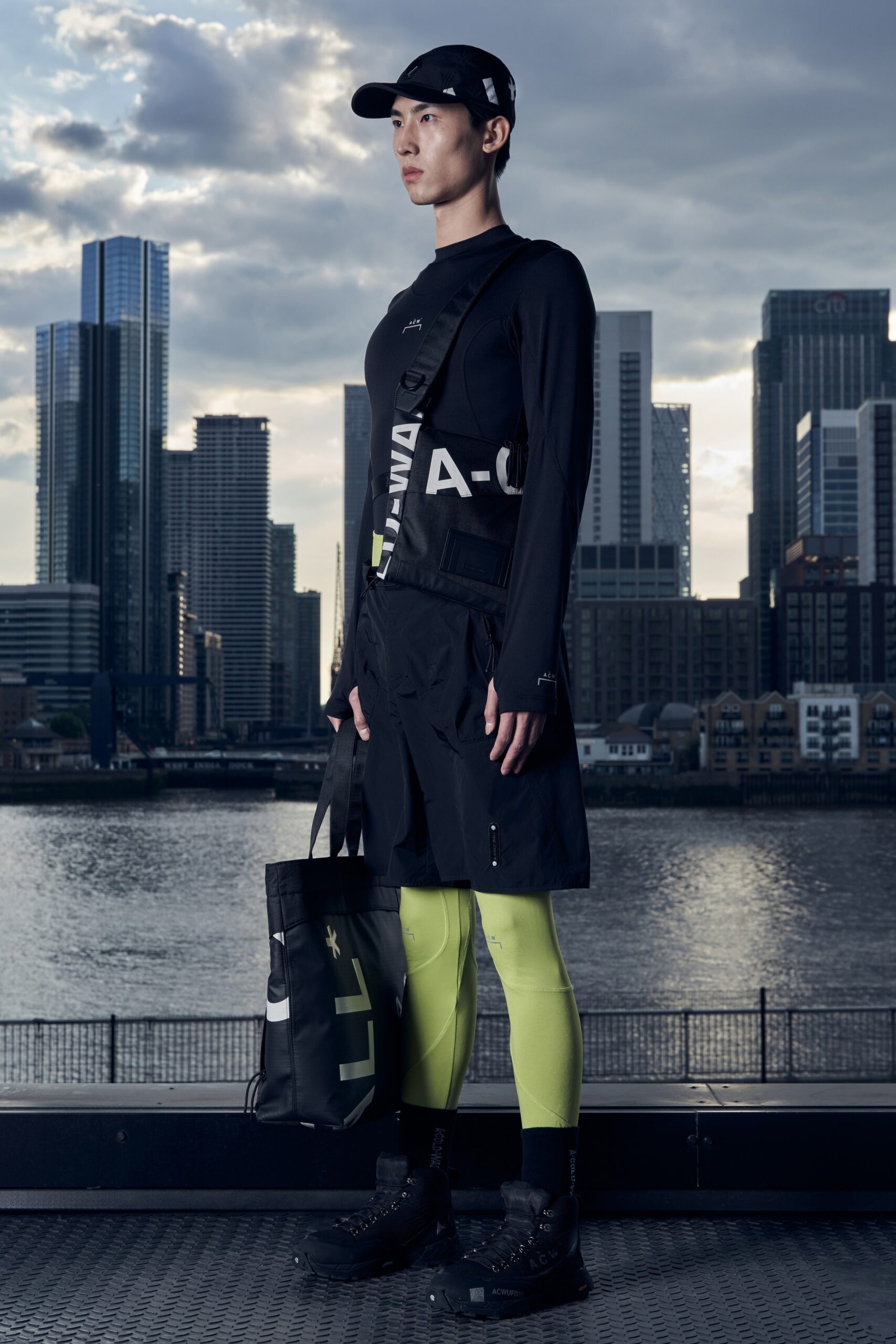 A fitted black asymmetric dress paired with yellow leggings and long sleeves.