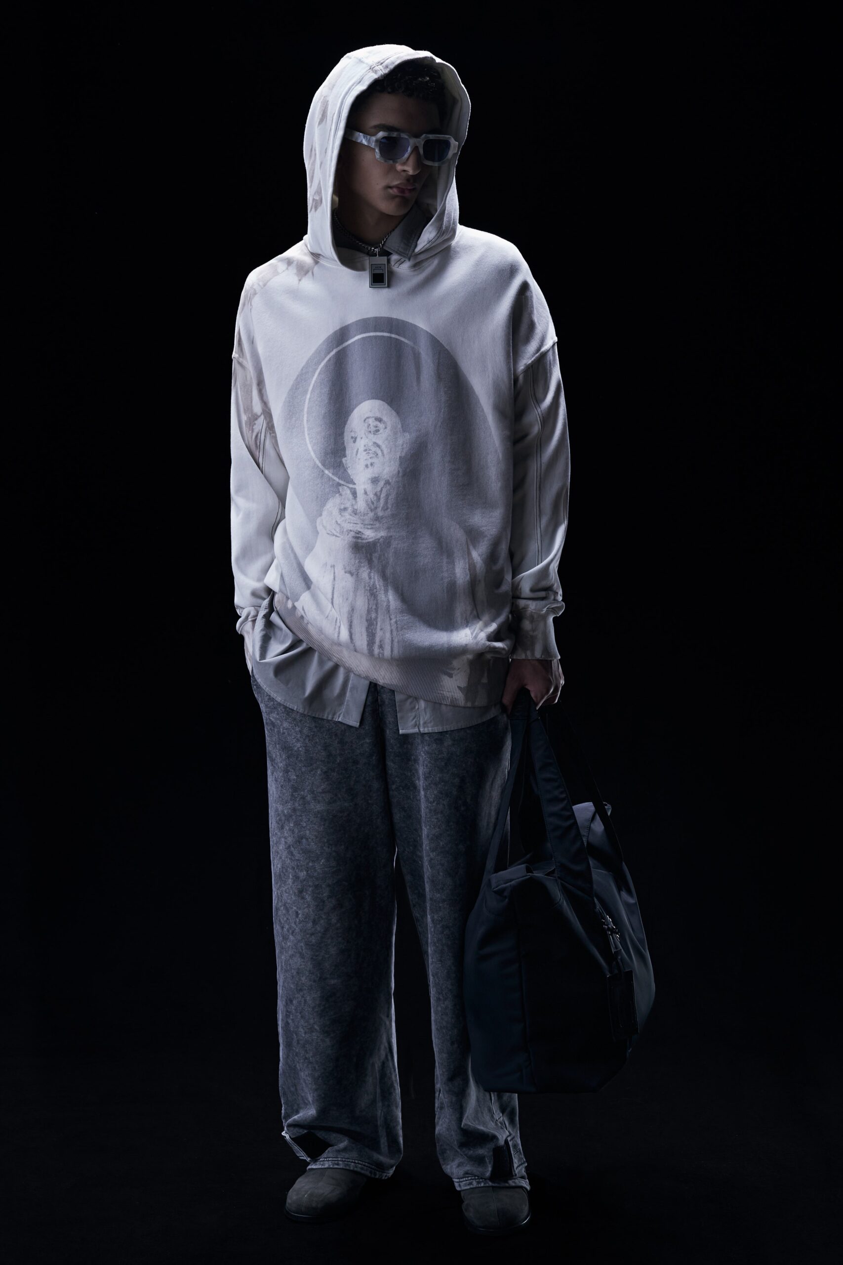 This relaxed hoodie features a striking print that draws the eye, complemented by wide-leg pants that enhance the overall silhouette. The combination of soft cotton and a hood adds a contemporary edge, creating a casual yet thoughtful look.