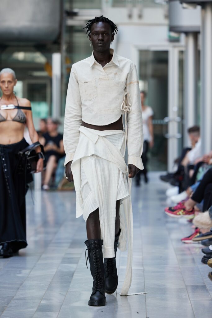 An asymmetric white cotton shirt paired with a flowing white skirt for a modern look.