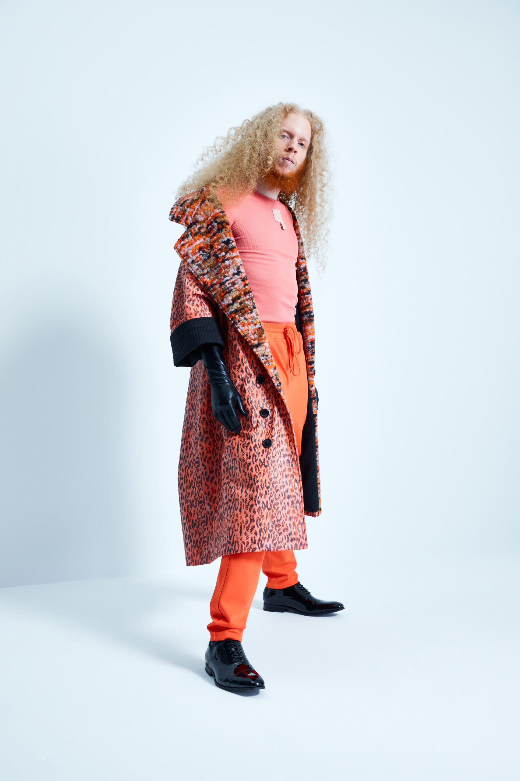 This coat features a vibrant multi-colored print that adds a bold statement to the ensemble. Paired with relaxed-fit pants, the look balances playful patterns with comfortable silhouettes, creating an eye-catching yet effortless style.