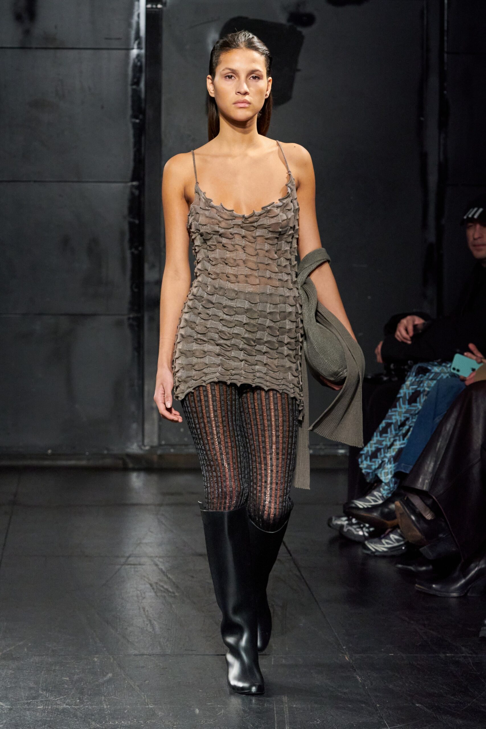 A fitted gray mesh sleeveless dress with a V-neckline and layered design detail.