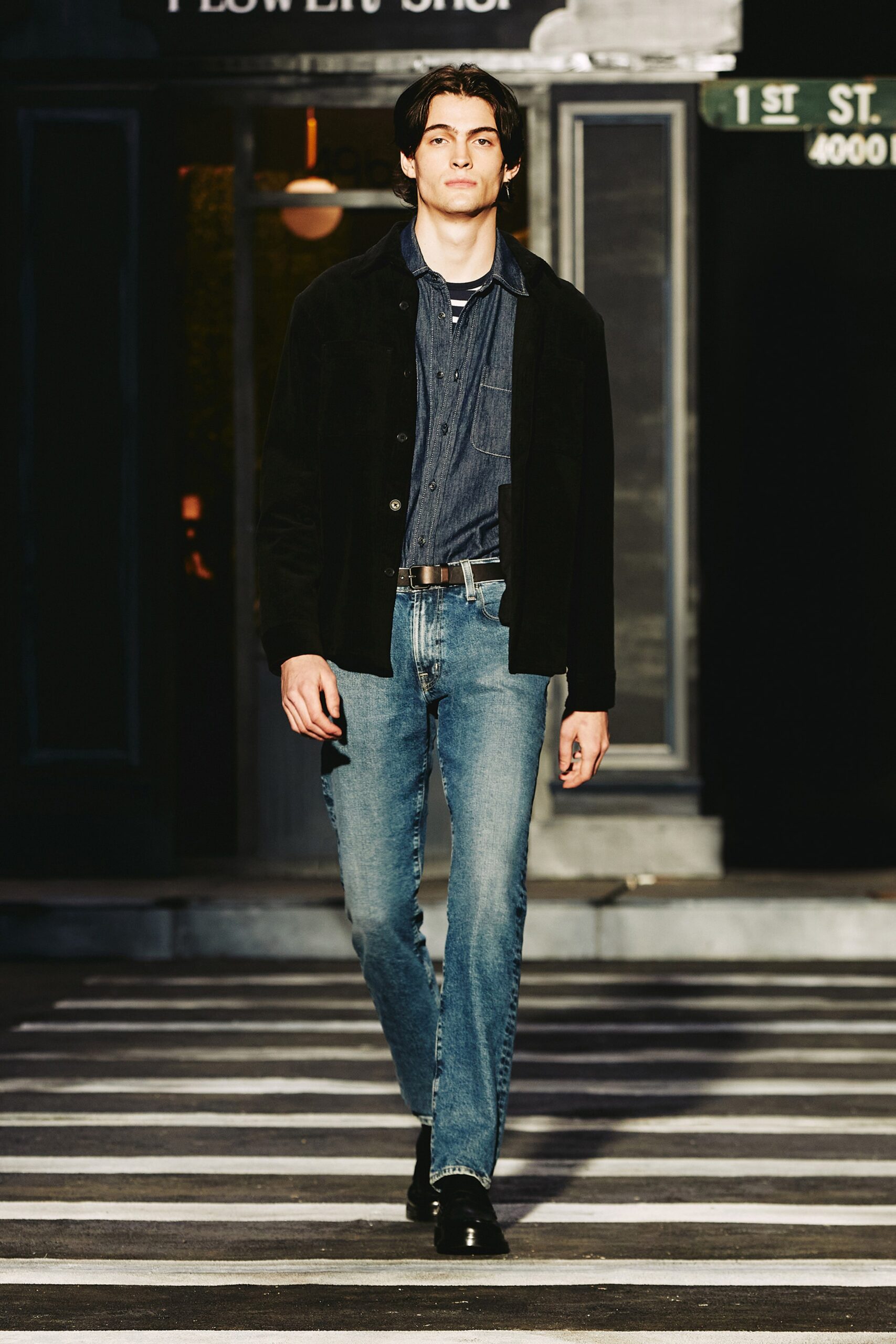 A fitted black jacket paired with blue straight-leg jeans for a stylish look.