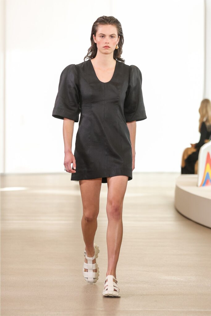 A fitted black silk mini dress with a V-neckline and short sleeves.