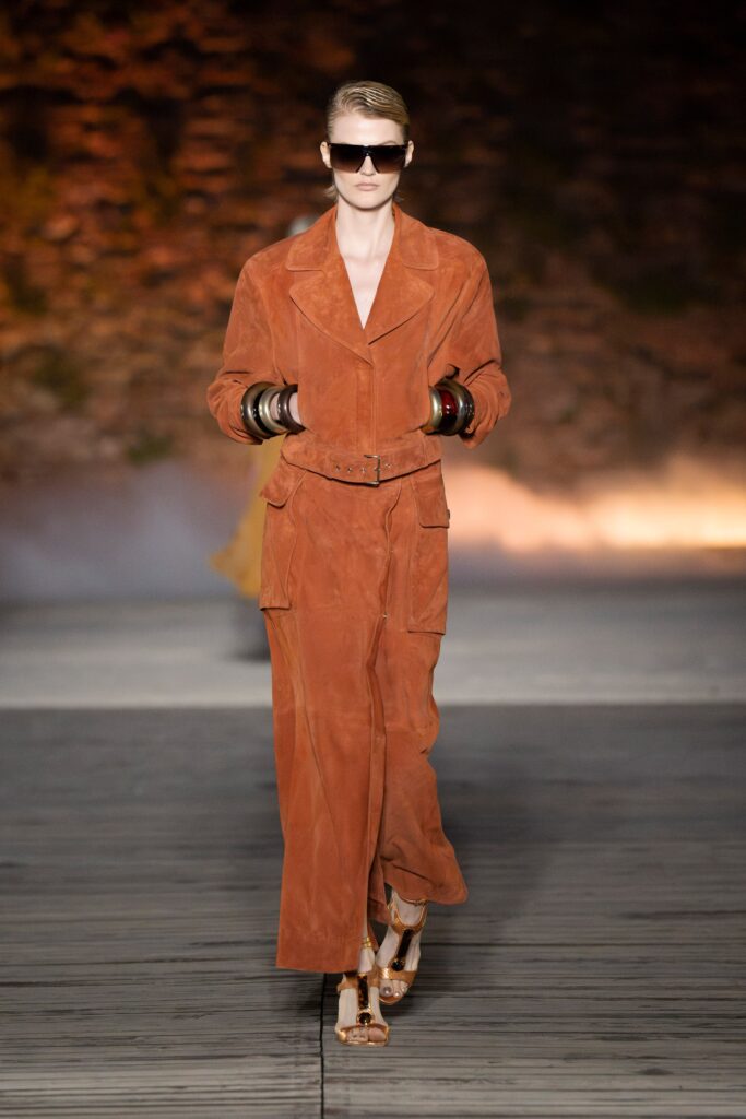 A relaxed brown suede jumpsuit with a collared neckline and belted detail.