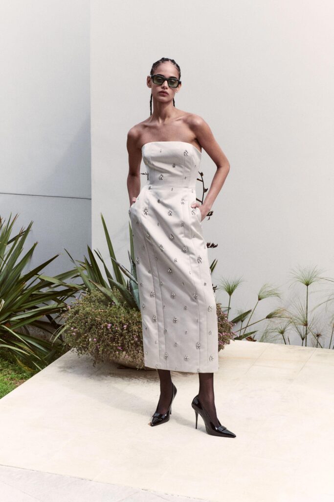 A fitted beige strapless dress featuring intricate embroidery for a sophisticated look.