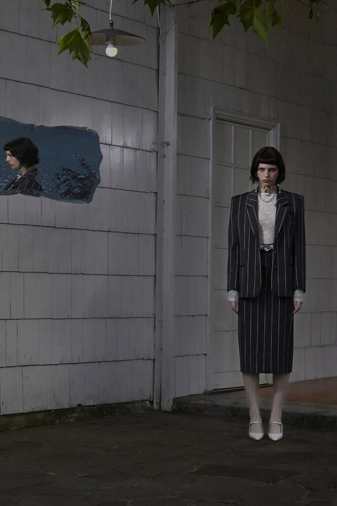 A fitted black and white striped suit with a collared long-sleeve shirt and pencil skirt.