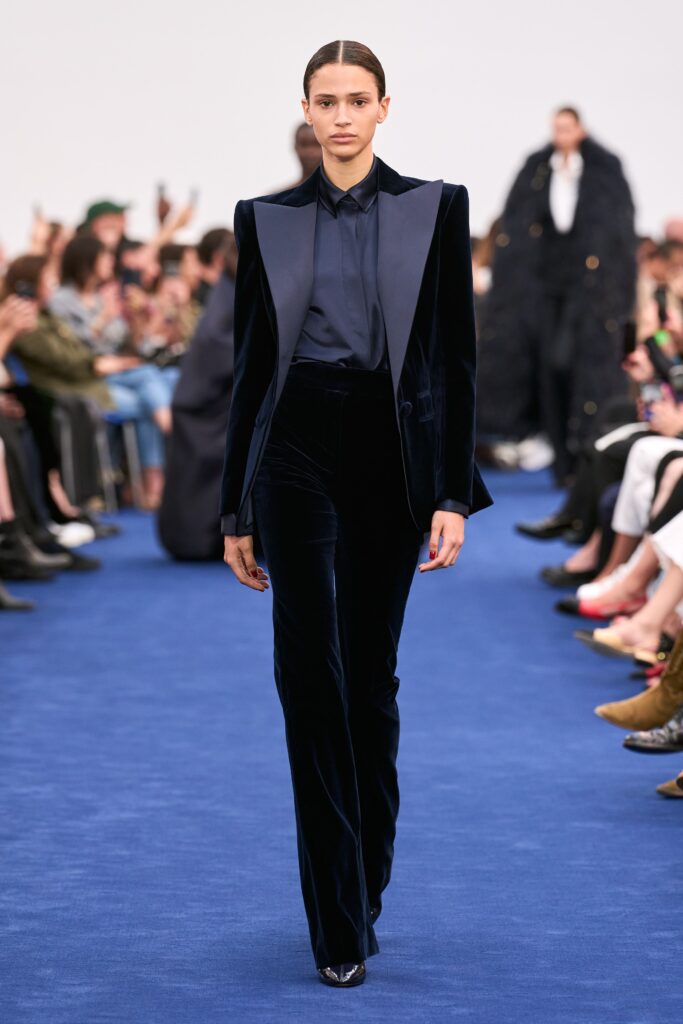A fitted navy velvet suit with a collared long-sleeve shirt and tailored silhouette.