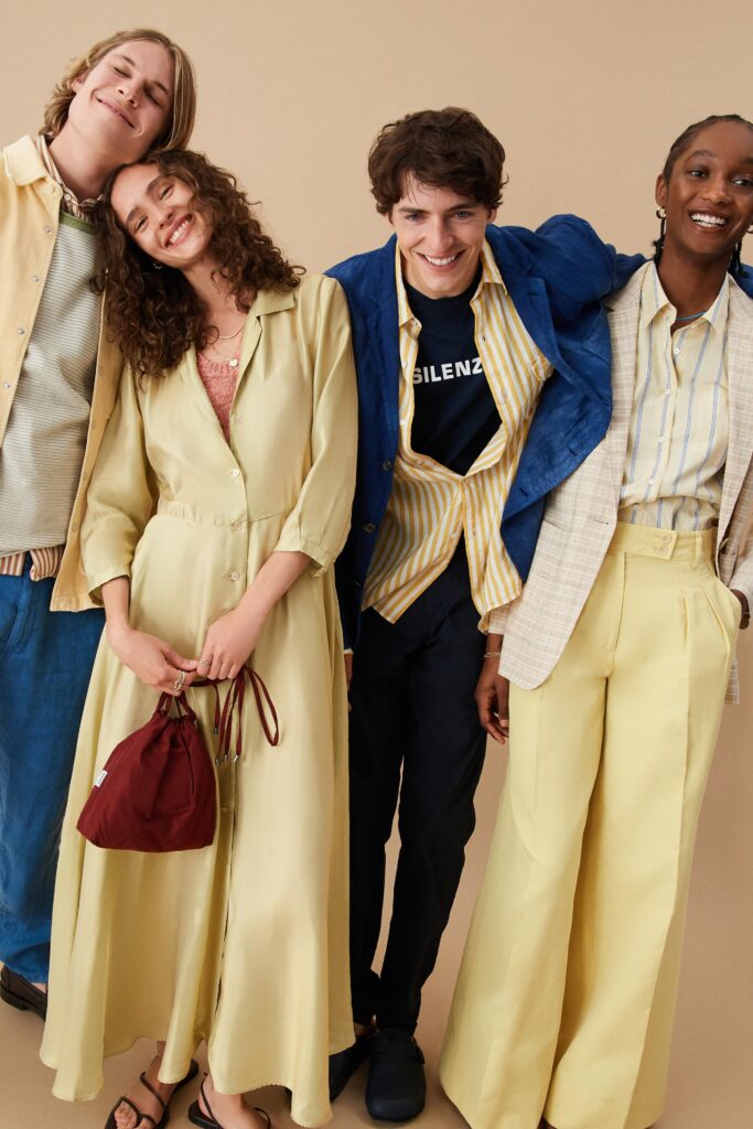 A relaxed yellow cotton dress with long sleeves and a collared neckline featuring a tiered design.