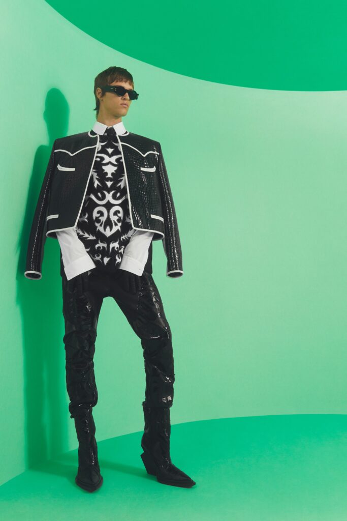 An oversized black jacket with white detailing paired with fitted black pants.
