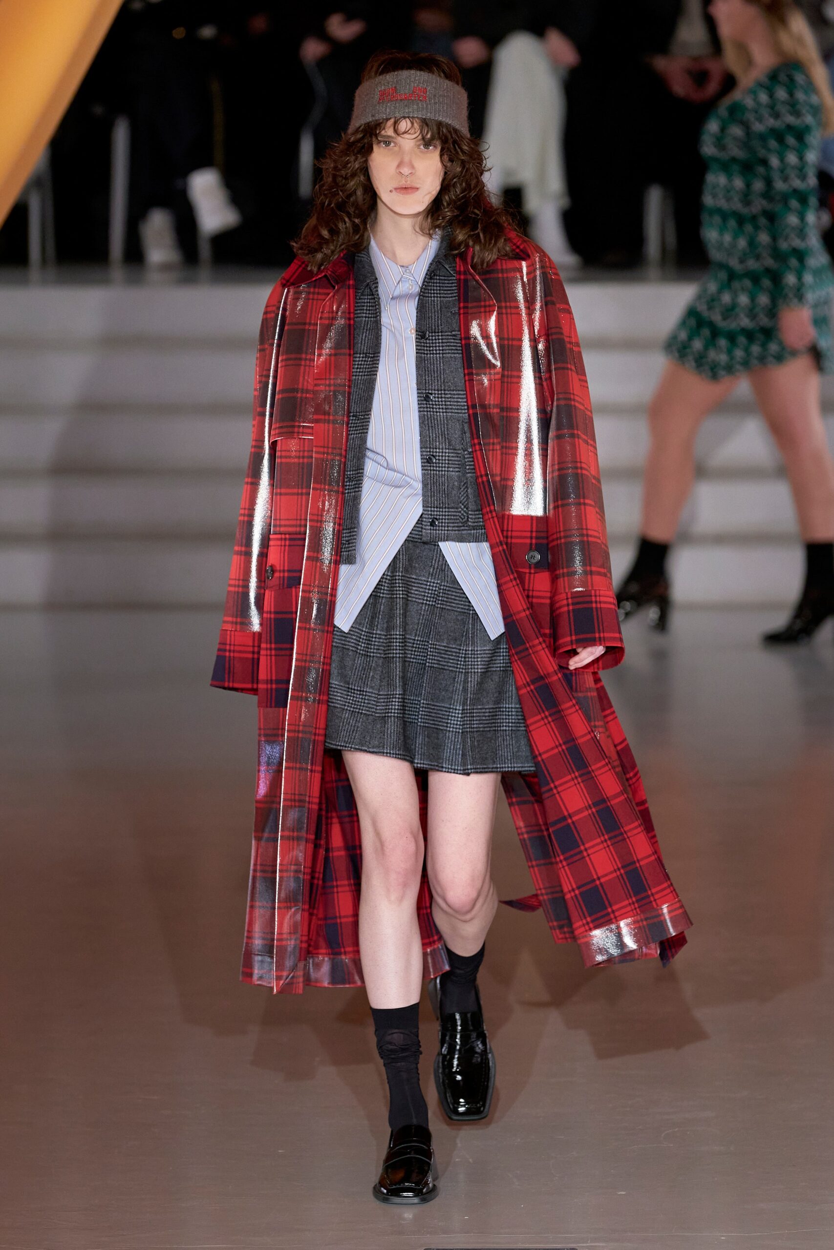 A fitted red plaid leather coat paired with a stylish skirt, featuring a collared design.