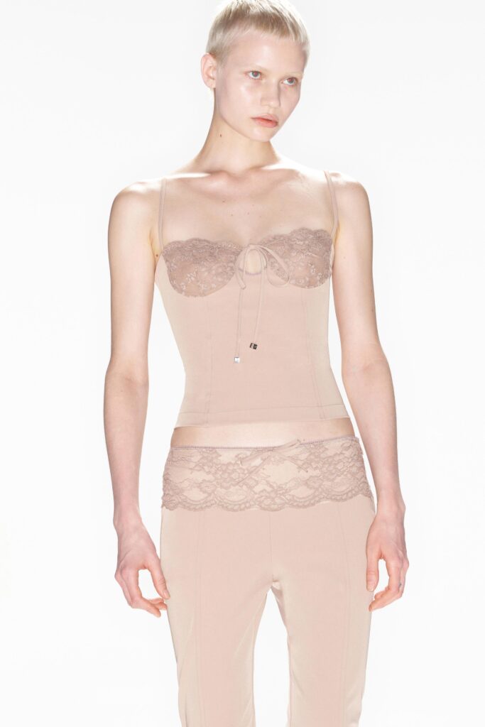 A fitted beige silk top with lace detailing and matching fitted pants.
