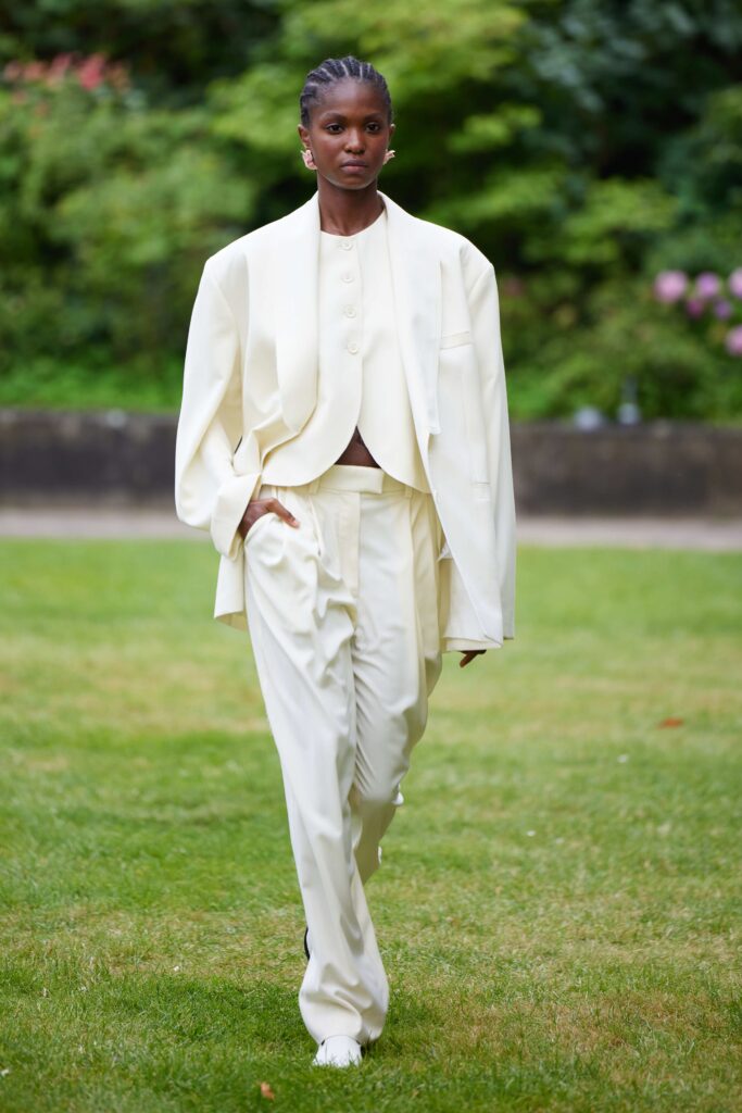 An oversized white buttoned suit featuring wide-leg trousers and a cropped jacket.