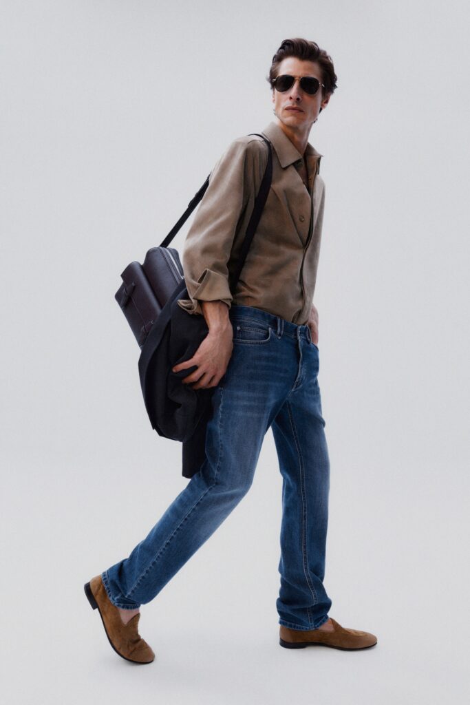 A relaxed-fit beige long-sleeve collared shirt paired with straight-leg blue denim jeans.
