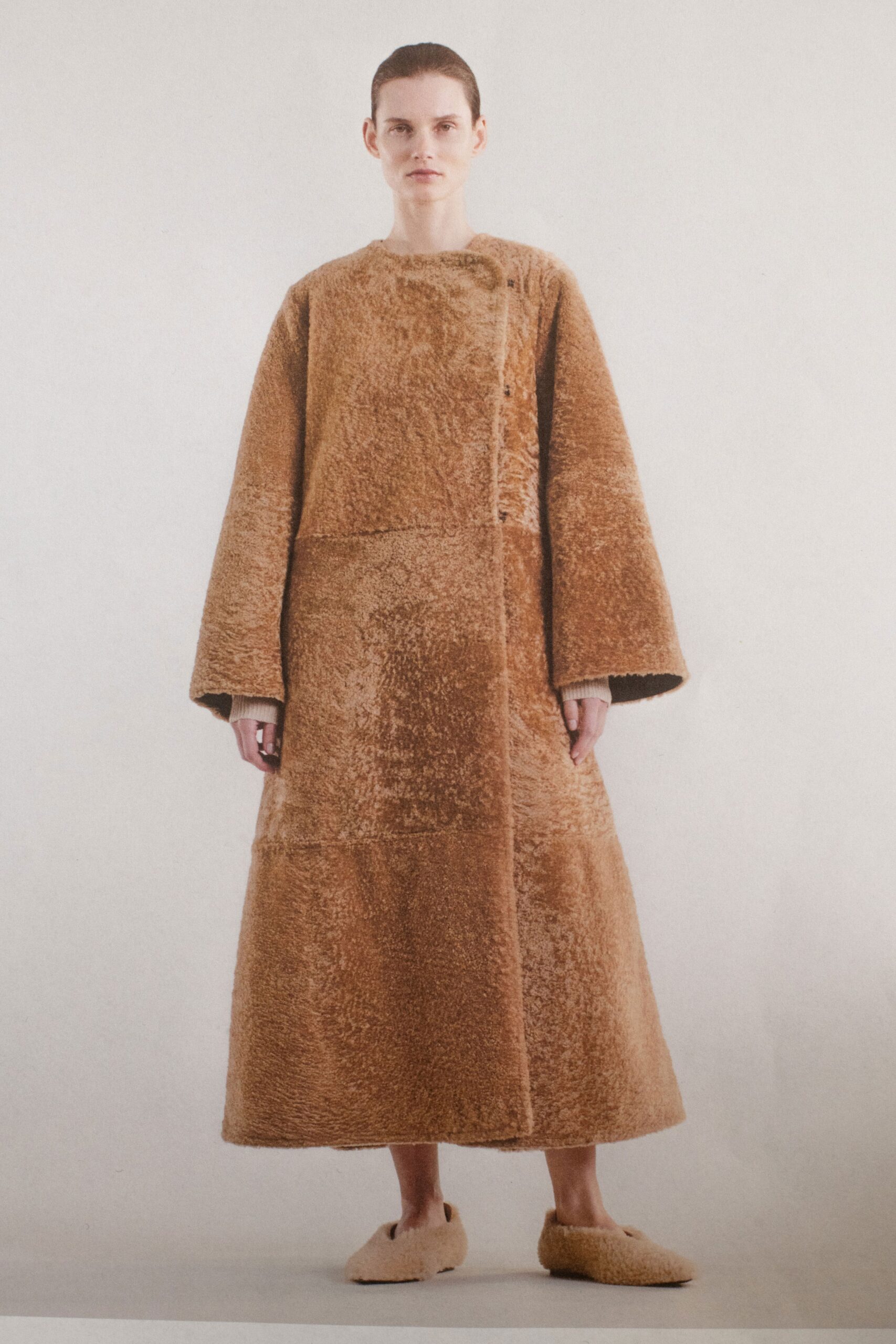 A relaxed brown fur coat with long sleeves and a collared design.