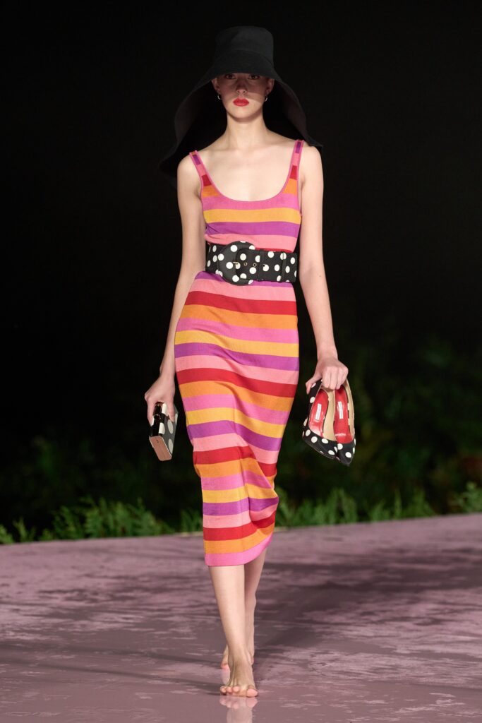 A fitted sleeveless dress with a V-neckline, featuring bold pink and orange stripes.