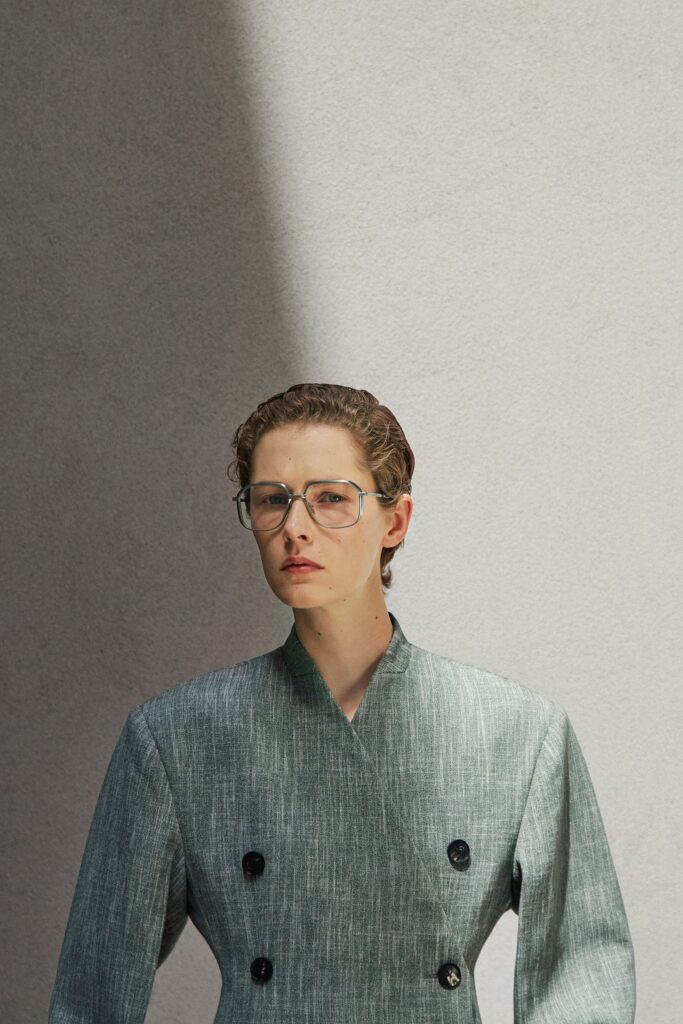 A structured gray cotton blazer with long sleeves and a collared design featuring button details.