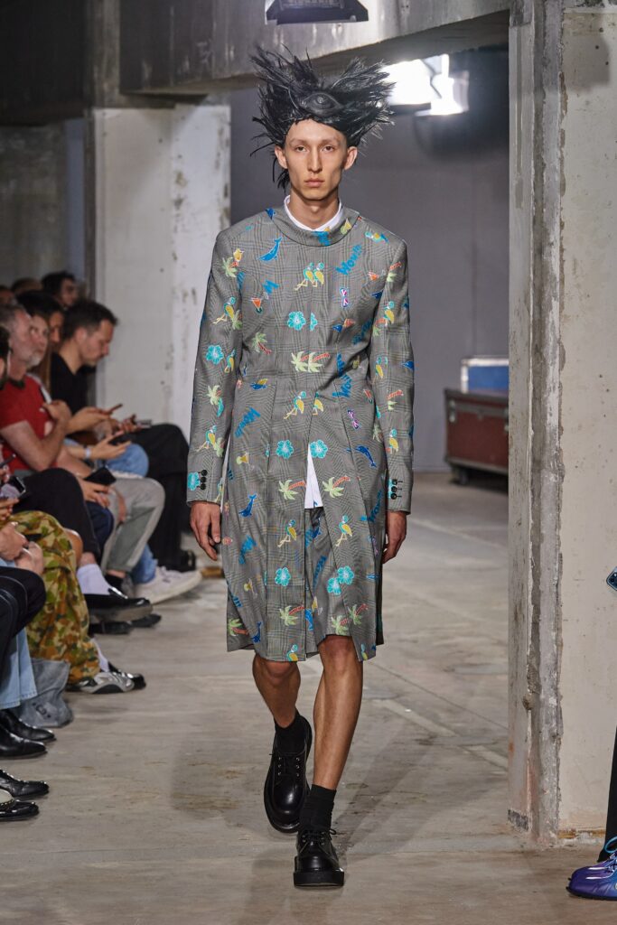 A relaxed gray coat with long sleeves, a collared neckline, and a vibrant printed design.