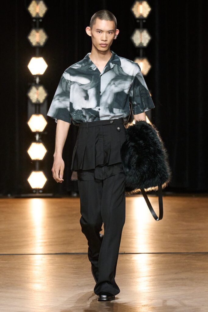 A relaxed black and white printed shirt with short sleeves paired with wide-leg pants.