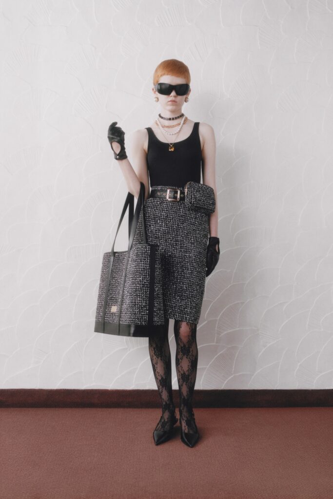A fitted black sleeveless top paired with a pencil skirt in a black and white tweed pattern.