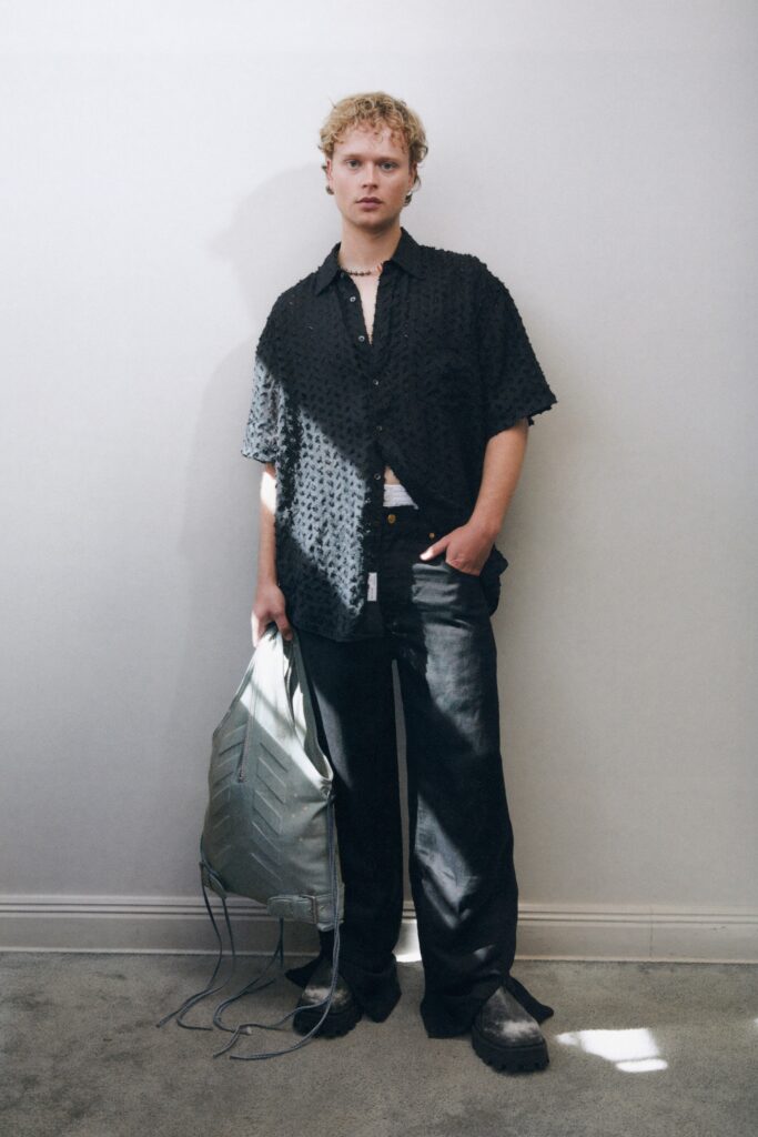 A relaxed black cotton shirt with short sleeves and textured design paired with matching pants.