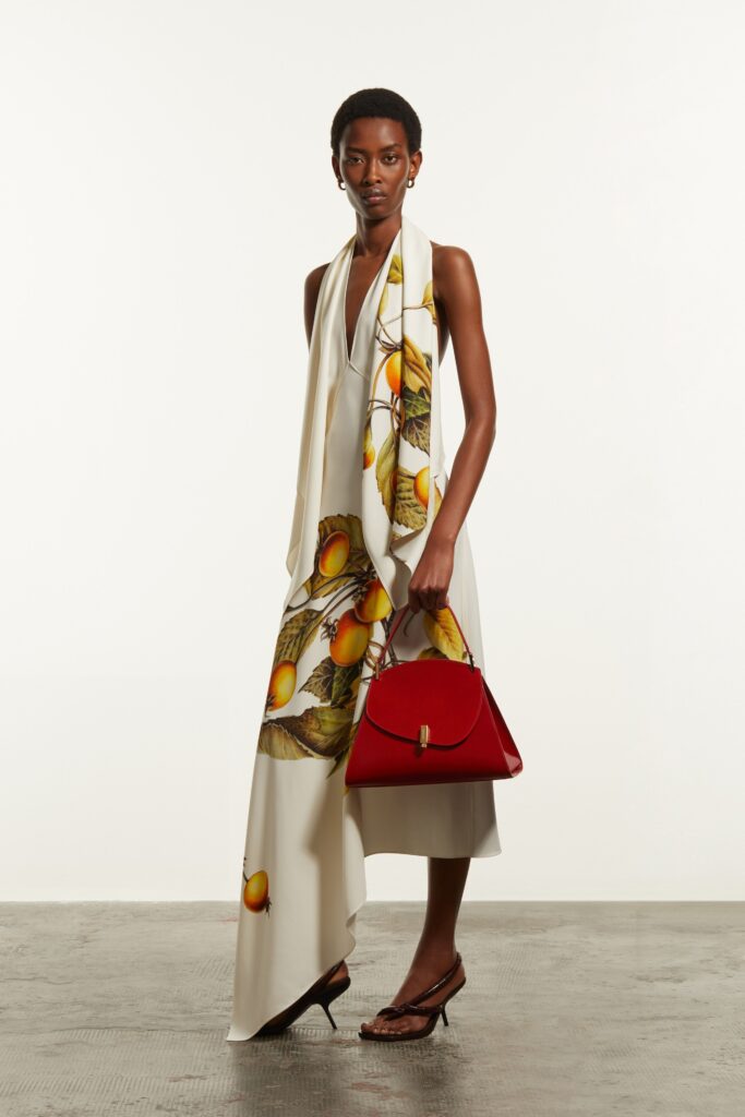 A relaxed white silk sleeveless dress with a V-neckline and printed design.