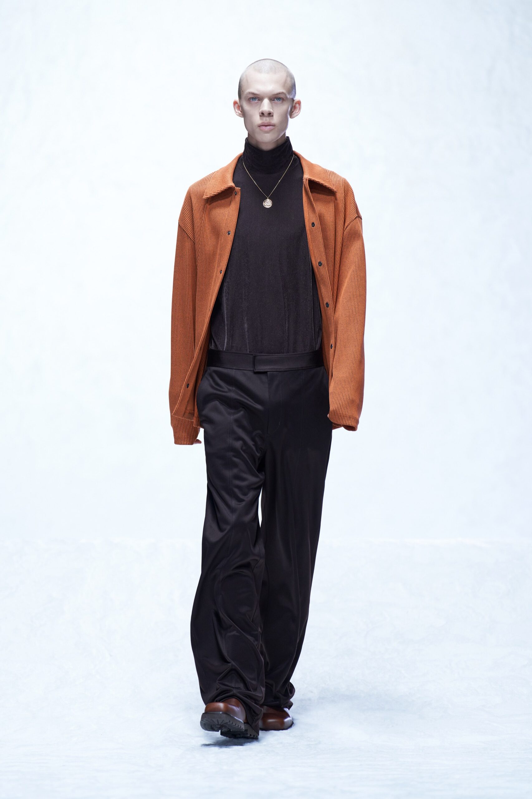 A relaxed-fit orange cotton jacket with a collared neckline paired with black straight-leg pants.