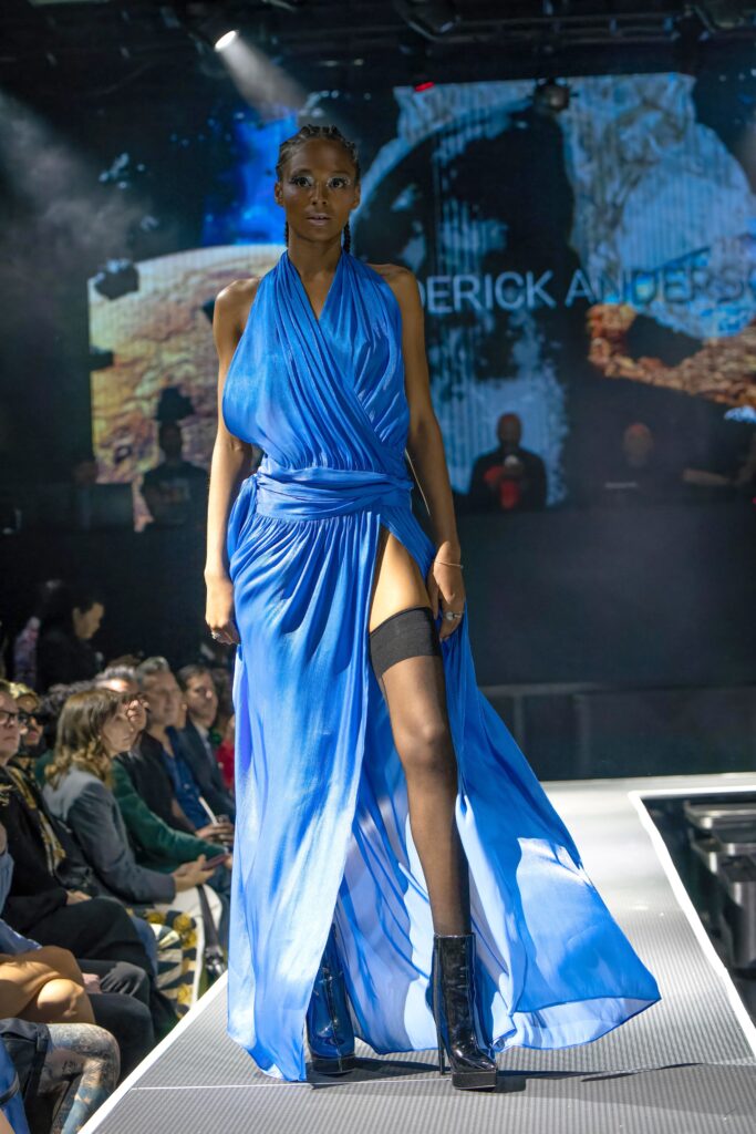 A fitted blue silk sleeveless dress with a V-neckline and a maxi silhouette featuring a slit.