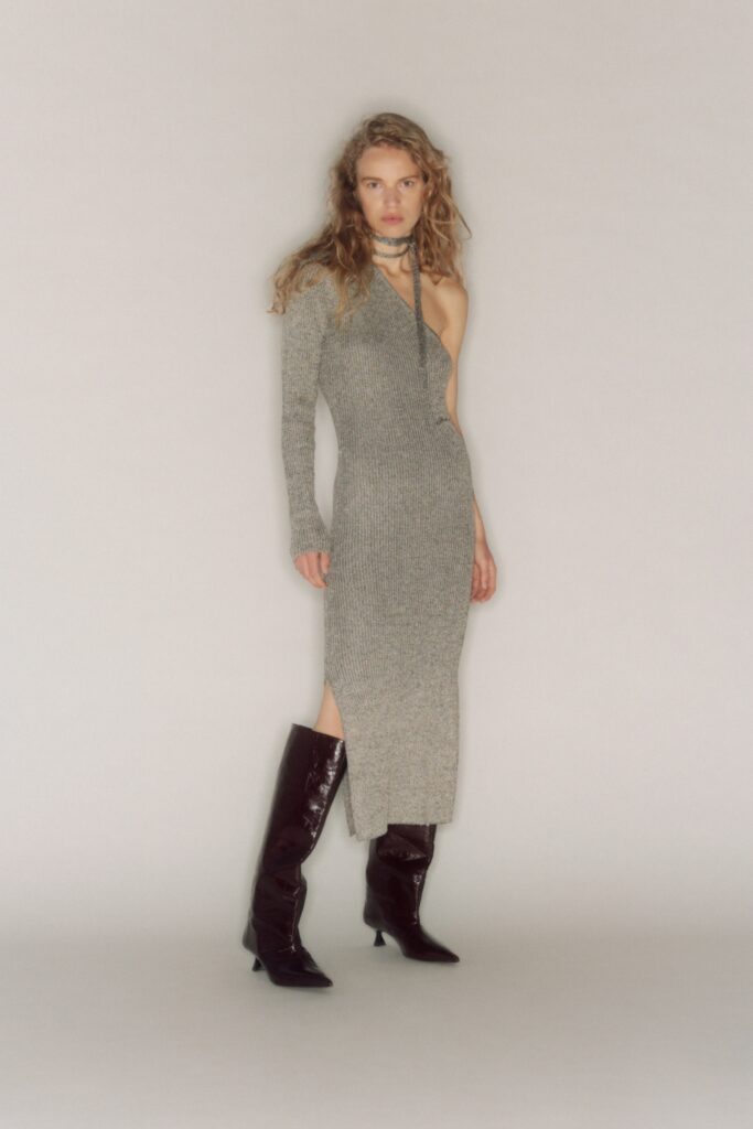 A fitted gray knit dress with a V-neckline and side slit detail.