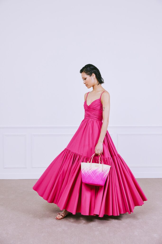A fitted pink sleeveless dress with a V-neckline and tiered silhouette.