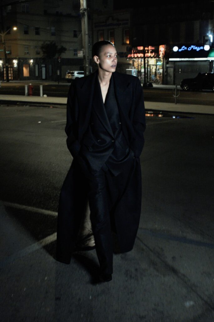 A fitted black wool coat with long sleeves and structured design paired with matching pants.