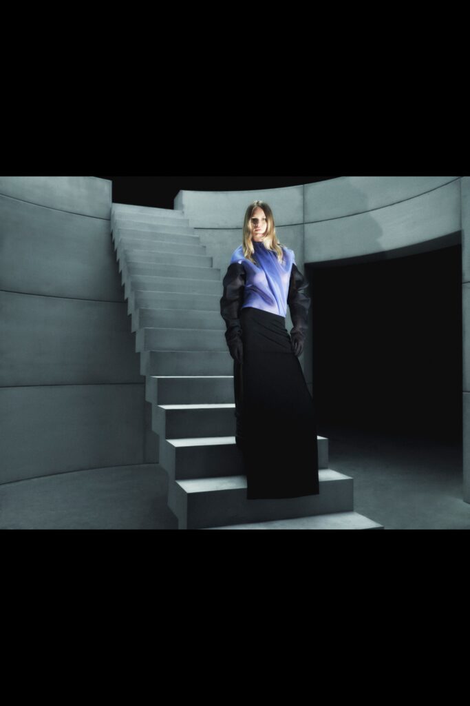 A fitted black and blue dress with long sleeves and an asymmetric design.
