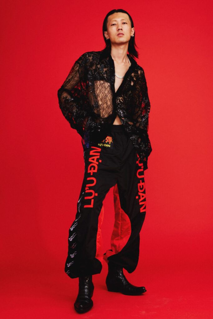A relaxed black lace long-sleeve shirt paired with printed red pants.