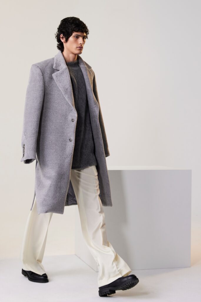 A relaxed gray wool coat paired with a white long-sleeve top, featuring a collared design.