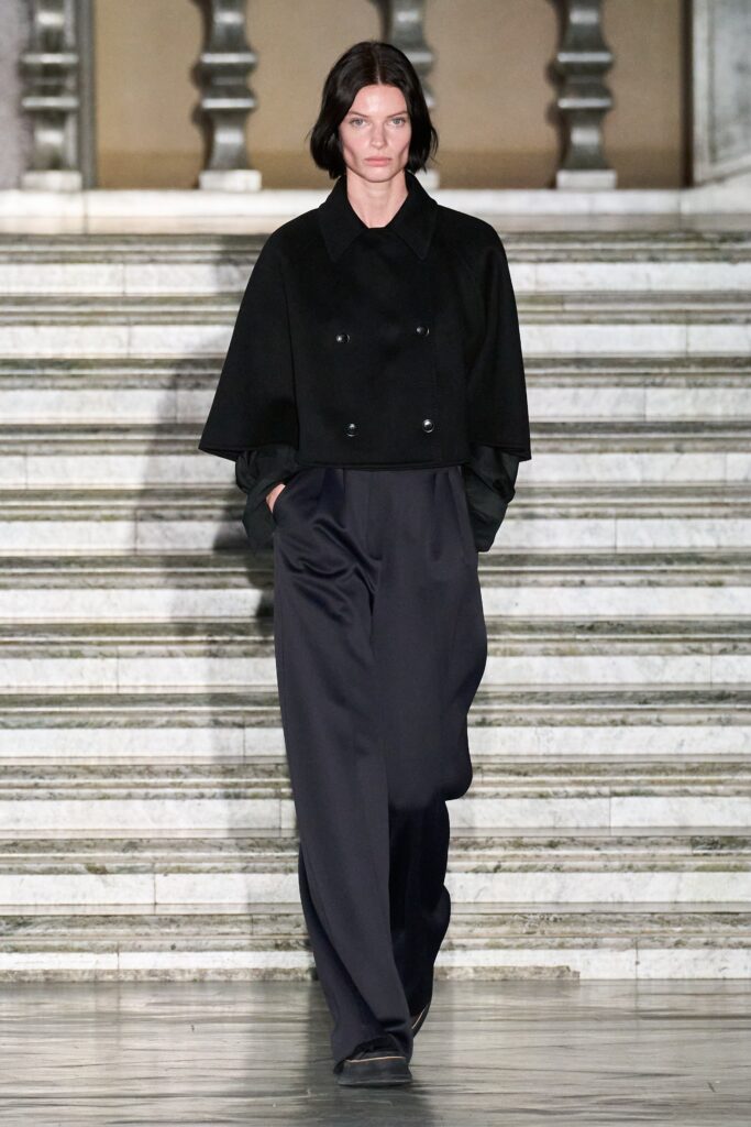 A relaxed black wool jacket with a collared design paired with wide-leg pants.
