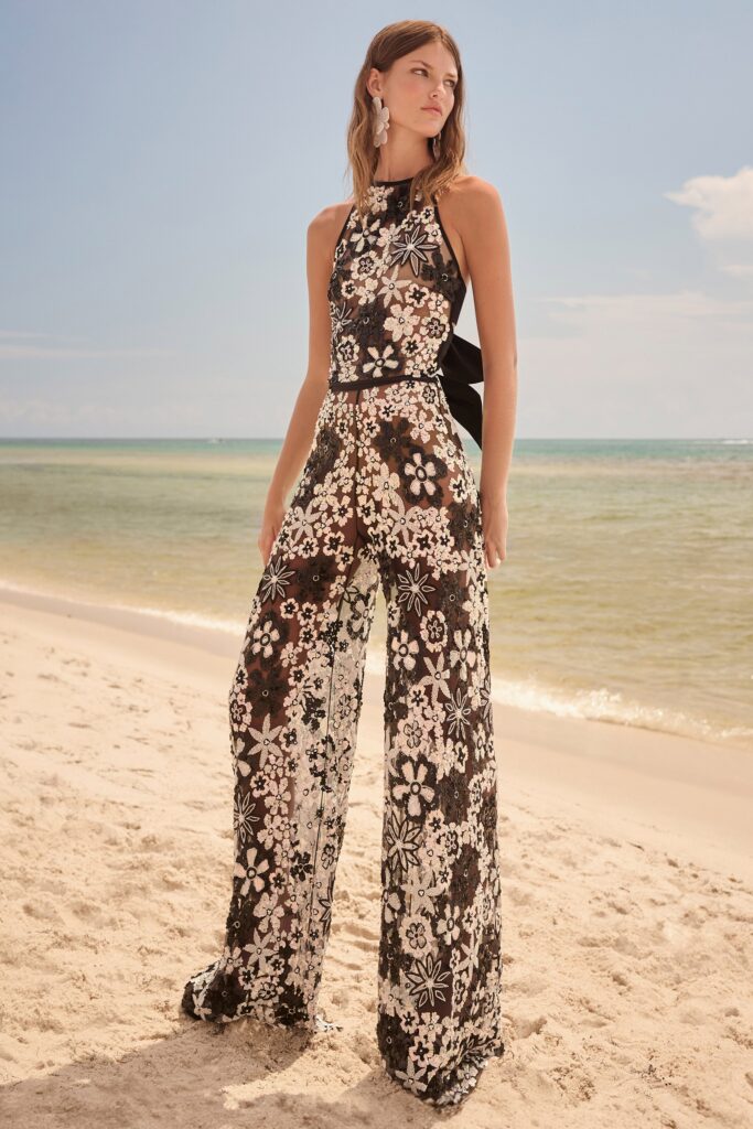 A fitted black and white floral jumpsuit with a sleeveless design and flared legs.