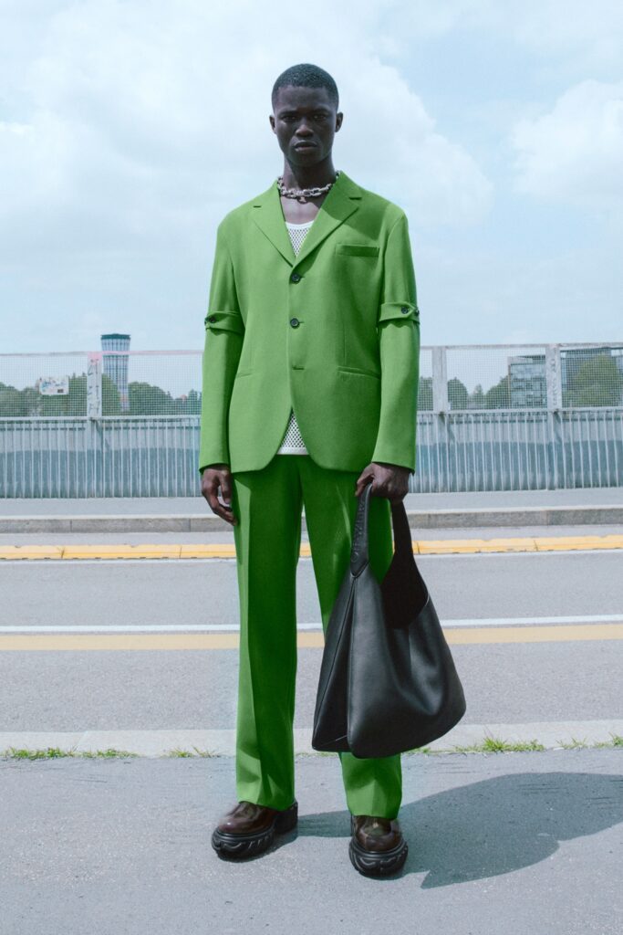 green tailored suit with black bag