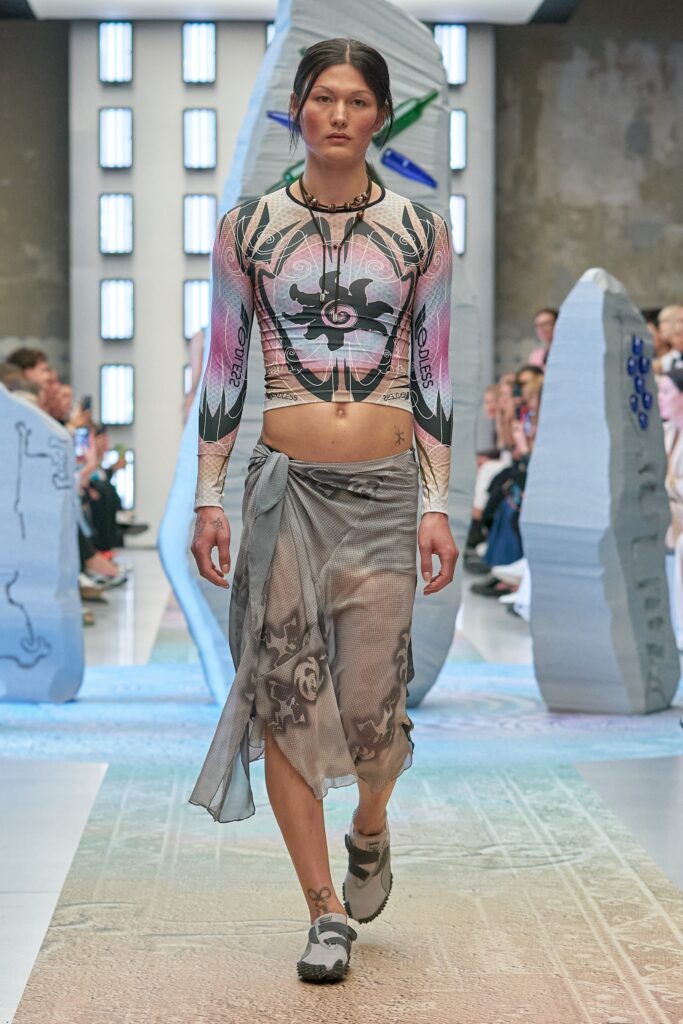 A fitted multicolor long-sleeve top with a high-neck and an asymmetric layered skirt.