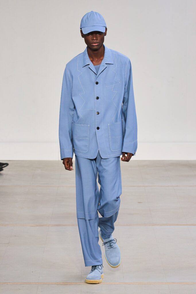 A relaxed blue cotton suit featuring long sleeves and a collared design with button details.