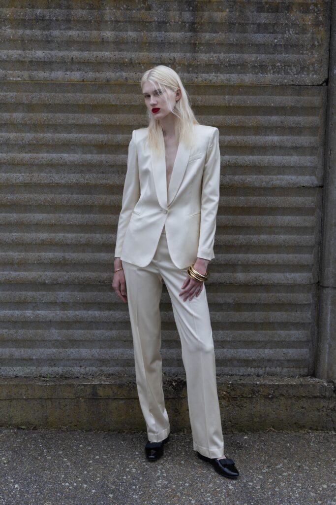 A tailored cream silk suit with a V-neckline and straight-leg pants.