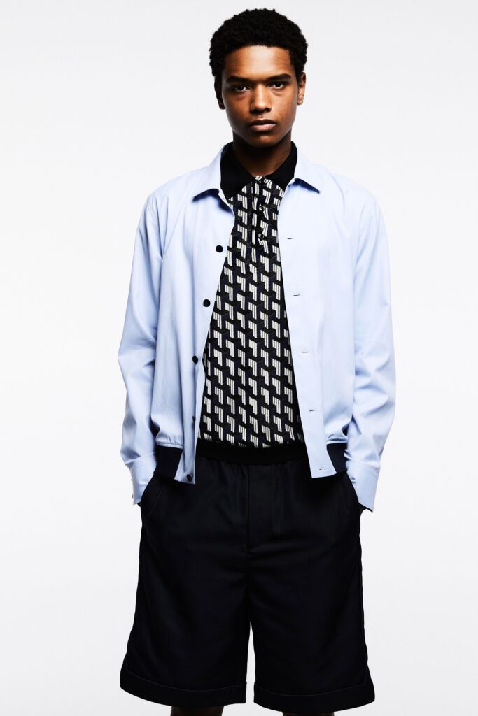 A relaxed blue collared shirt paired with black printed shorts for a casual look.