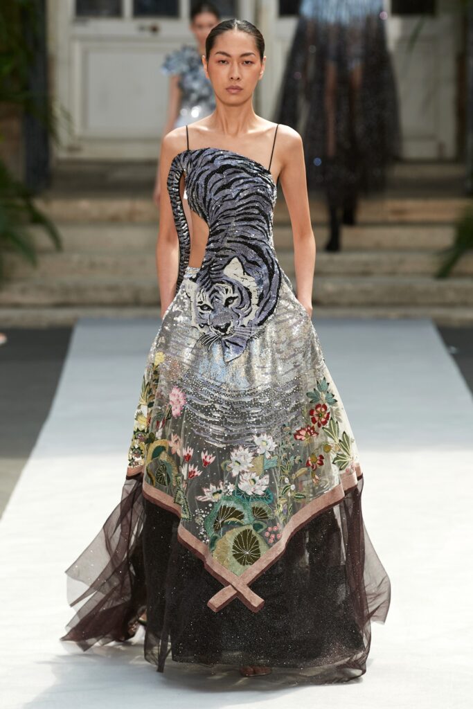 A fitted black and multicolor embroidered dress with a sleeveless design and asymmetric details.