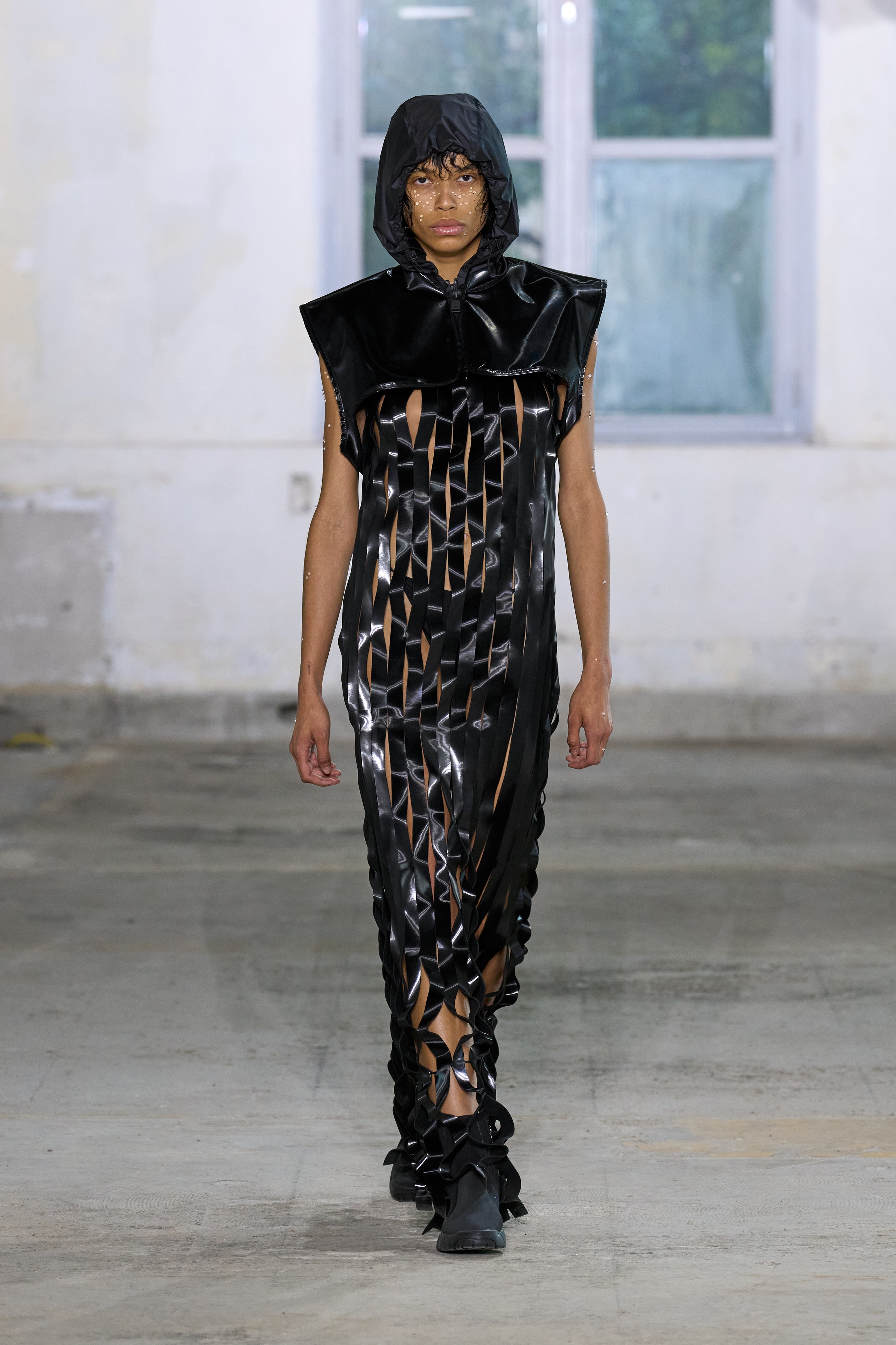 A fitted black leather dress with a sleeveless design and asymmetric details.