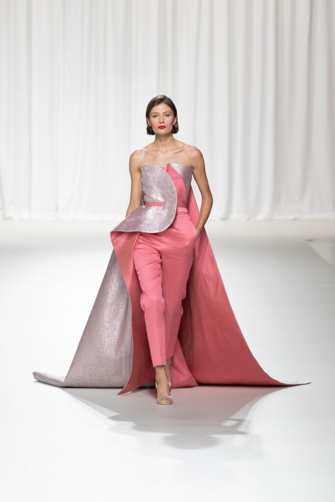 A fitted pink silk sleeveless dress with an asymmetric layered design.