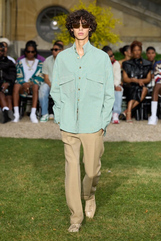 A relaxed fit green striped long-sleeve shirt paired with beige pants.