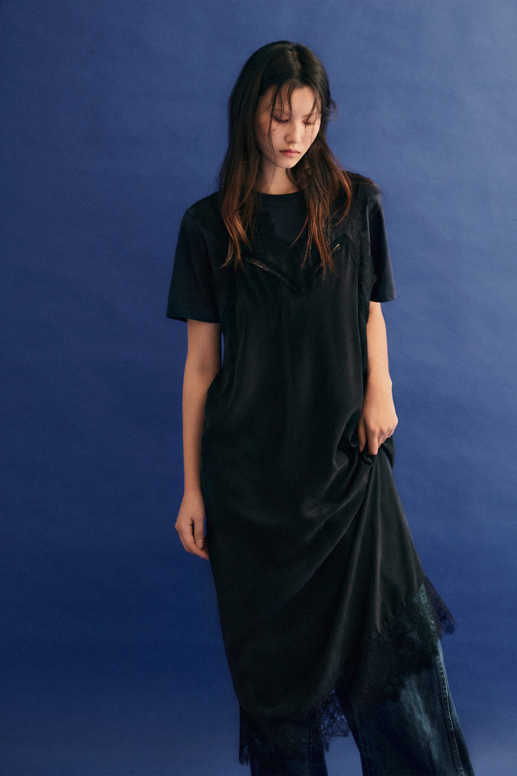 A relaxed black silk dress with short sleeves and a V-neckline, featuring a layered design.