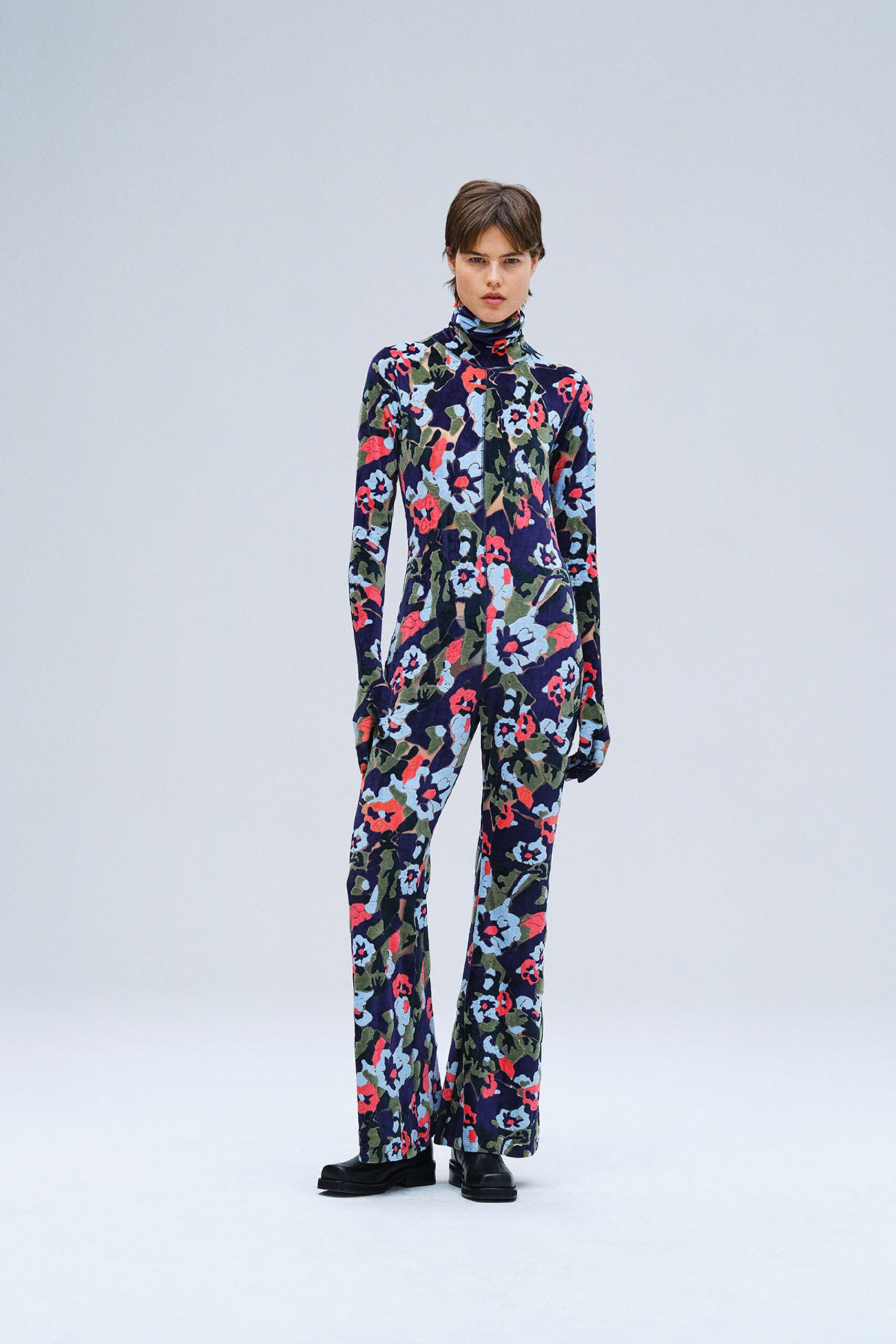 A fitted multicolor jumpsuit with long sleeves and a collared neckline featuring a flared design.